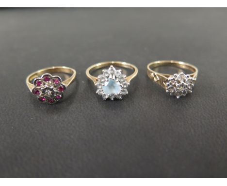 Three 9ct gold cluster rings - To include diamond, ruby and diamond, together with topaz and white-gem - Hallmarked London an