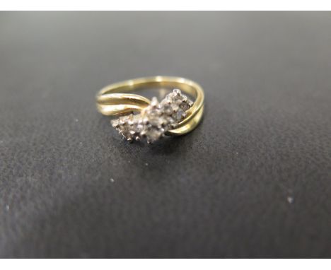 A diamond cluster crossover ring - Stamped 18ct - Ring size P - Weight approx 4.2gms
Condition Report: Good - With light scra