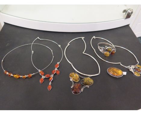 A group of amber-like jewellery - To include four necklaces, a bangle and a carved brooch - All with marks indicating silver 