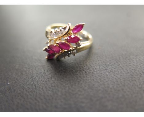 A ruby and diamond crossover style dress ring - The marquise-cut rubies to the brilliant-cut diamond shoulders - Stamped 14K 