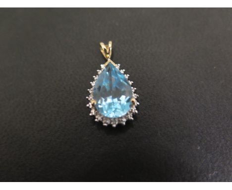 A 9ct gold topaz and diamond pendant - The pear-shape topaz Within a textured surround with single-cut diamond highlights - H