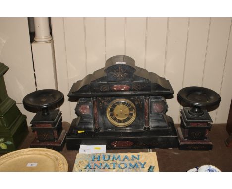 A Victorian slate and rouge marble mantel clock with a matching garnitures