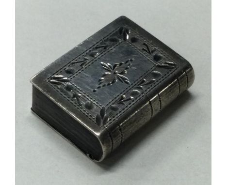 An engraved silver snuff box in the form of a book with hinged cover. Approx. 6 grams. Est. £30 - £40.