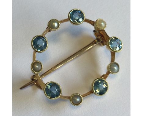A circular 15 carat gold pearl brooch set upon knife edge spacers. Approx. 2 grams. Est. £40 - £60.