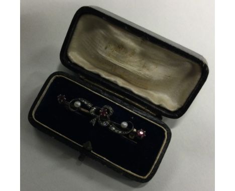 An attractive ruby, diamond and pearl brooch in the form of a clover with scroll decoration. Approx. 4 grams. Est. £150 - £20