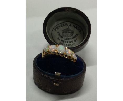 An attractive opal five stone ring of boat shaped form in 18 carat gold setting. Approx. 3 grams. Est. £250 - £300.