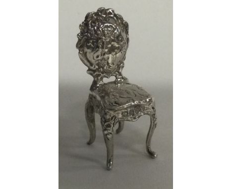 A toy silver model of a chair bearing import marks. Approx. 7 grams. Est. £20 - £30.