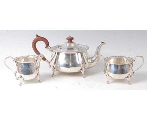 A George V silver three-piece tea set, comprising teapot, twin handled sugar and cream, each of squat circular form with pier