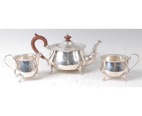 A George V silver three-piece tea set, comprising teapot, twin handled sugar and cream, each of squat circular form with pier