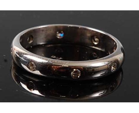 A 9ct white gold diamond full hoop ring, featuring eight round brilliant cut diamonds inset within a 3.35mm D-shaped band, di