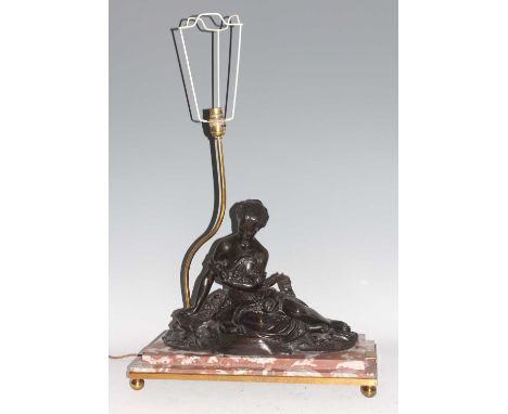 An early 20th century French bronze, rouge marble and gilt brass table lamp, the stepped base mounted with recumbent figure o