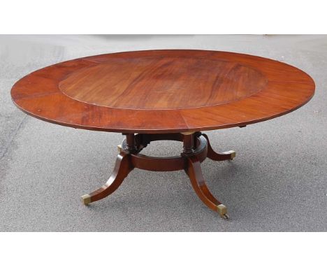 In the manner of Jupe - a Regency style mahogany radial extending dining table, all raised on four ring turned columns to squ