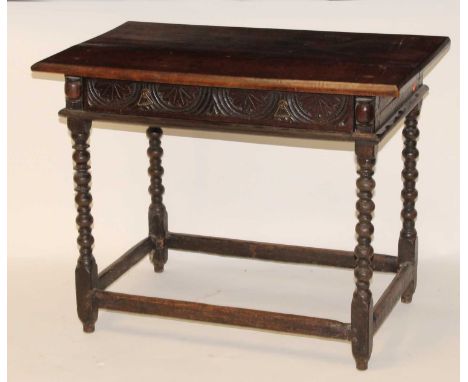 An antique joined oak side table, having a two-plank top over rosette blind carved frieze drawer, all raised on bobbin turned