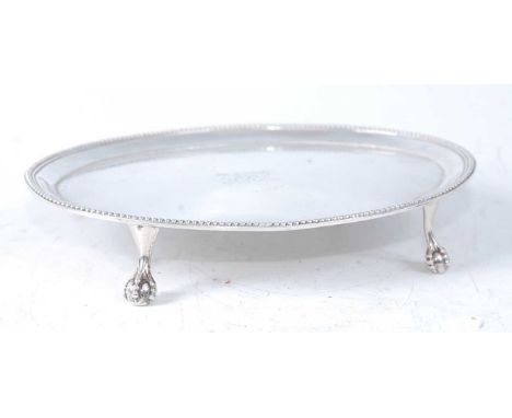 A George III silver teapot stand. of beaded oval form, having engraved monogram, all raised on claw and ball feet, 5oz, maker