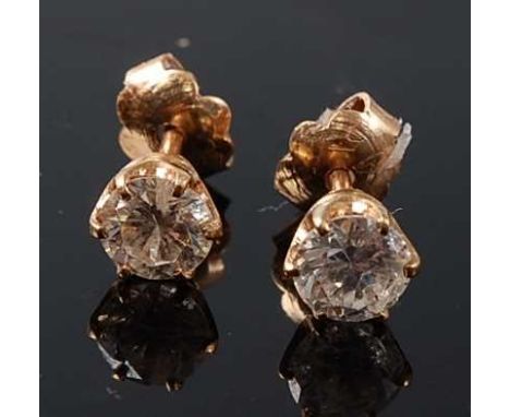 A pair of yellow metal diamond single stone stud earrings, each featuring a round brilliant cut diamond in a six-claw setting