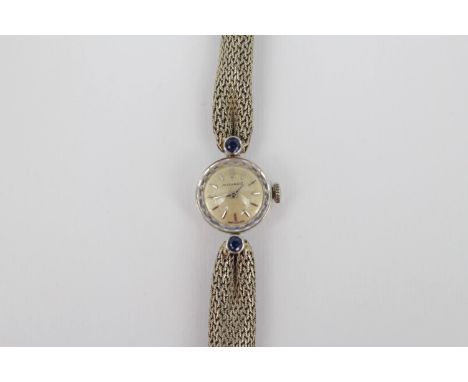 Movado; A lady's 18ct white gold Movado wristwatch, with baton indices and inset Sapphires to shoulders. 20g total weight (wi