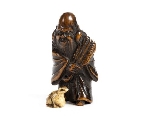 * Netsuke . A fine Japanese Meiji period ivory netsuke, carved as a man holding a fan formed from a leaf, 8cm high, together 