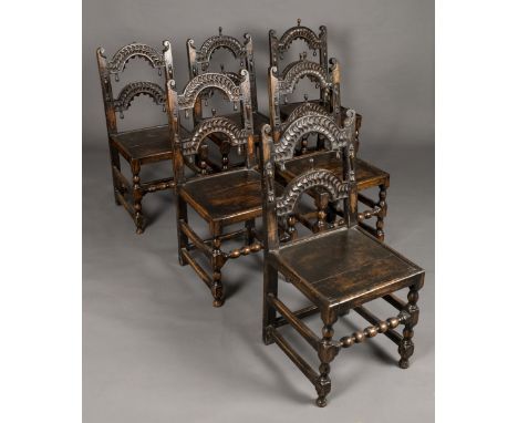 * Chairs. A set of six 19 th century carved oak dining chairs, each with carved arched top-rail and back-rail, solid seat on 