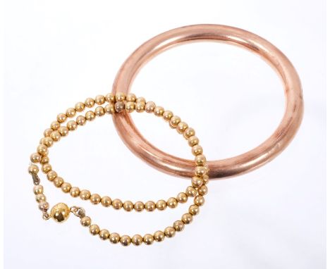 Yellow metal slave bangle and a similar bead necklace