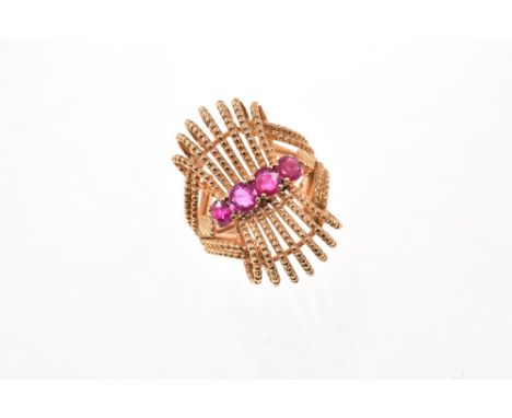 1950s/1960s ruby and gold cocktail ring with a beaded gold wire work scroll design and four round mixed cut rubies. Finger si