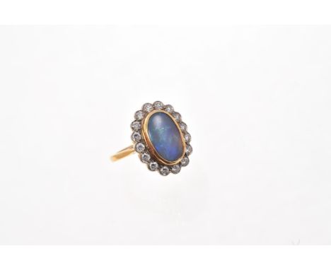 Opal and diamond cluster ring with an oval opal cabochon surrounded by a border of sixteen brilliant cut diamonds in mille gr