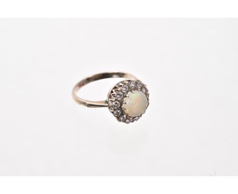 Opal and diamond cluster ring with a round opal cabochon 7.8mm surrounded by a border of thirteen brilliant cut diamonds in c