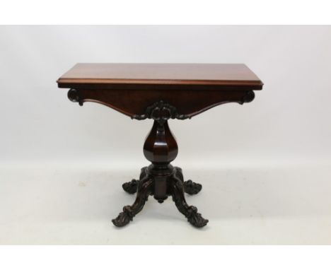 Early Victorian mahogany card table, the moulded rectangular fold-over top over carved frieze and octagonal bulbous column on