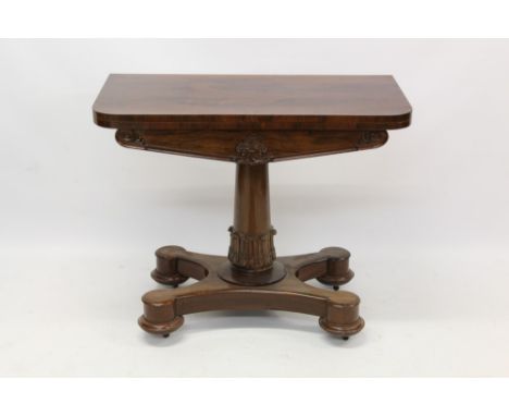 William IV rosewood card table with d-shaped fold-over top on lappet carved column and shaped platform on castors, 81cm wide