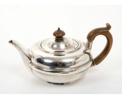 Edwardian silver teapot of compressed form, with fruitwood loop handle and hinged domed cover with turned fruitwood finial, o