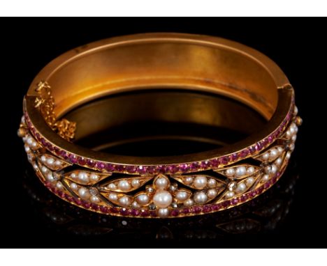 Victorian ruby, diamond and pearl hinged bangle with wide openwork band of foliate design, ruby border and matte gold finish