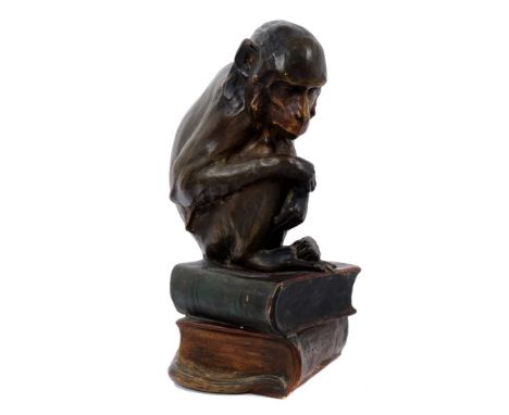 Late 19th century Austrian Goldscheider-style pottery figure of a monkey seated on a pile of books, with patinated painted fi