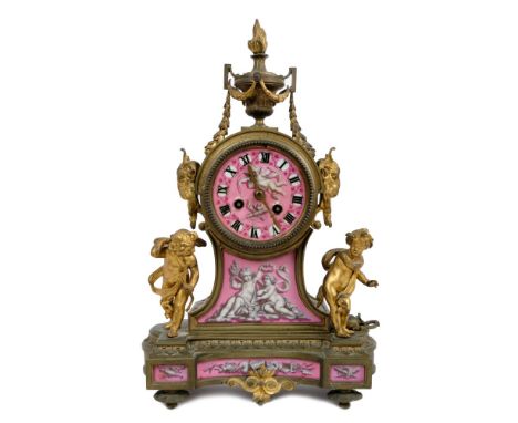 Late 19th century French gilt metal and porcelain mantel clock with urn finial, Cupid and muse mounts, ram's head side handle