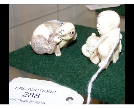 Carved ivory netsuke - small child holding tortoise, together with one other 