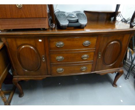 AN EARLY TWENTIETH CENTURY WALNUTWOOD BOW FRONTED SIDEBOARD WITH LEDGE BACK, THREE CENTRE DRAWERS, END CUPBOARDS ON CABRIOLE 