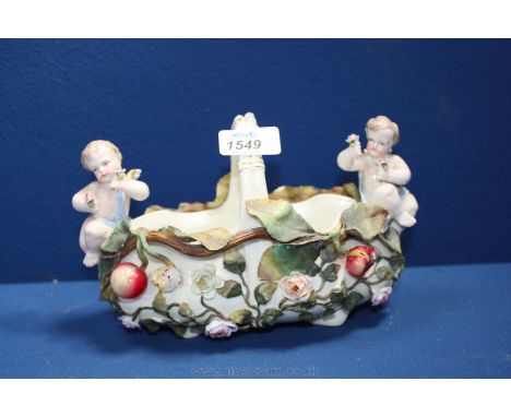 A Dresden Bowl decorated with cherubs, flowers and fruit, 9" long, 5 1/2" tall