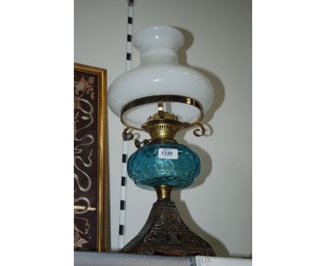 An Oil Lamp having metal base with blue glass reservoir and white shade