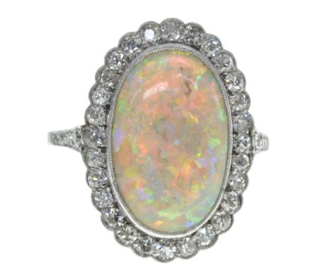 Set with opal approx. 15 x 10 mm. surrounded by diamonds, ring size 17.