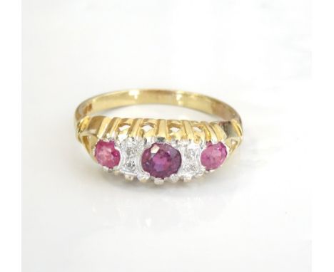 RUBY AND DIAMOND DRESS RING the three rubies separated by small diamonds, on nine carat gold shank, ring size I-J