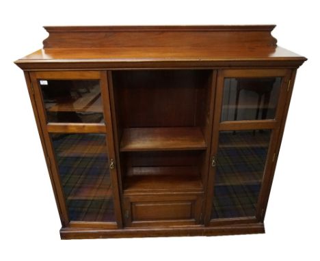 EDWARDIAN MAHOGANY BOOKCASEwith shaped backrail, central open adjustable shelf compartment, flanked by glazed doors with adju