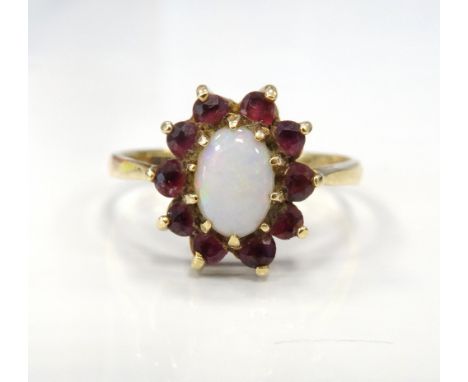 OPAL AND RUBY CLUSTER RINGthe central oval cabochon opal in ten diamond surround, on nine carat gold shank, ring size N