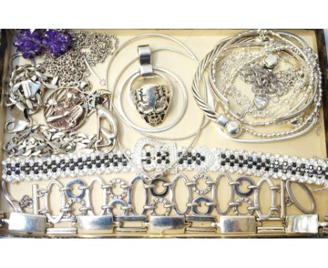 SELECTION OF SILVER JEWELLERYincluding bracelets, bangles, a pair of amethyst set earrings, a stylized dog brooch, and a skul