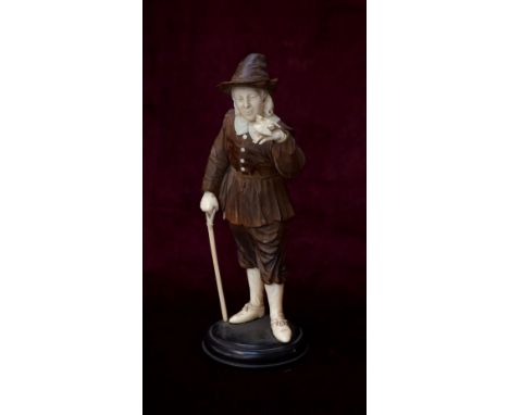 19th CENTURY GERMAN CARVED IVORY AND STAINED WOOD FIGURE OF A NOBLEMANwith a bird perched to his raised left hand and with a 