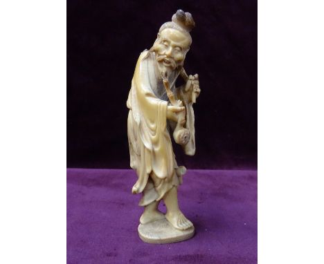 19th CENTURY CHINESE CARVED IVORY FIGURE OF AN OLD MANin flowing robes and smoking a pipe, 13.3cm high