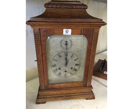 A large early 20th century oak cased chiming mantle clock manufactured by Gustav Becker with original key and pendulum.