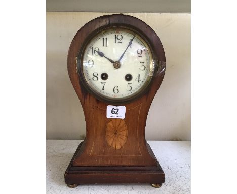 A mahogany cased balloon shaped mantle clock with enamel circular dial.