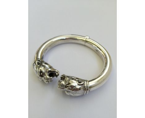 A heavy silver bangle decorated with a Panther.