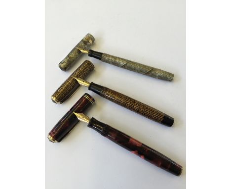 Two vintage Parker Vacumatic fountain pens, one in a golden web style pattern with another in a burgundy pattern together wit