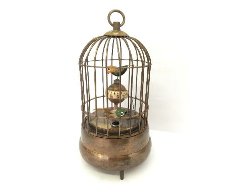 A brass cased clockwork automaton style clock modelled as a birdcage.