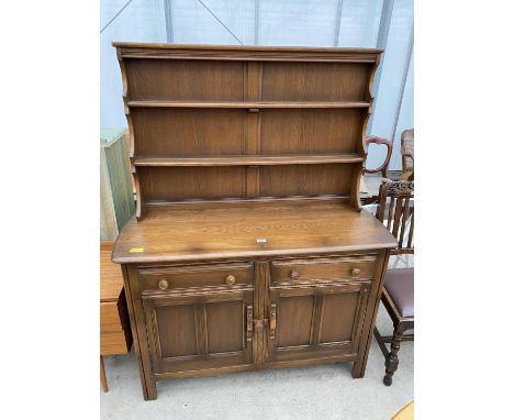 AN ERCOL DRESSER WITH CUPBOARDS AND DRAWERS TO THE BASE, COMPLETE WITH PLATE RACK, 48" WIDE 