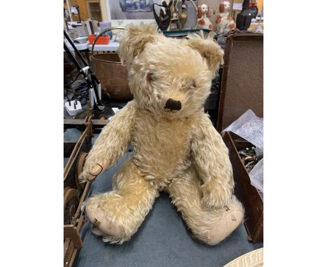 A VINTAGE MERRYTHOUGHT TEDDY BEAR WITH A BUTTON IN HIS EAR AND LABEL TO FOOT 